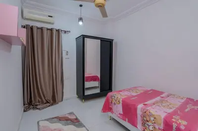 a bedroom with a mirror and a bed with pink sheets at Madares sweet home appartment in Hurghada