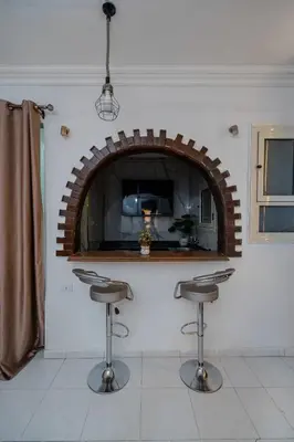 a kitchen with a bar with stools in a room at Madares sweet home appartment in Hurghada