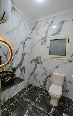 a bathroom with a toilet and a tv on the wall at Madares sweet home appartment in Hurghada