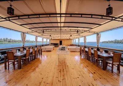 a restaurant on a boat with tables and chairs at Anoush Dahabiya 7 nights from Luxor to Luxor each Monday in Luxor