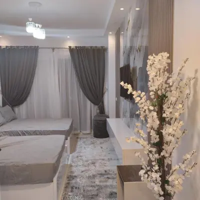 a room with two beds and a vase of flowers at Florenza khamsin Resort Hurghada Red Sea in Hurghada