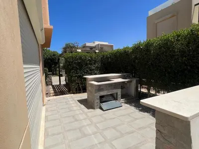a patio with a stone fire pit in a yard at Tawila 3BR Family Townhouse • Lagoon Retreat Villa in Hurghada