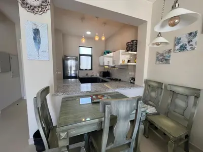 a dining room with a table and chairs and a kitchen at Tawila 3BR Family Townhouse • Lagoon Retreat Villa in Hurghada