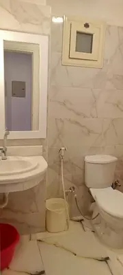 a bathroom with a toilet and a sink and a mirror at شقه للايجار غرفه وصاله ومطبخ وحمام بالهضبه الغردقه in Hurghada