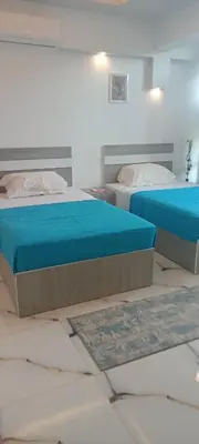 two beds in a room with two rugs on the floor at شقه للايجار غرفه وصاله ومطبخ وحمام بالهضبه الغردقه in Hurghada