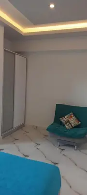 a room with a green couch and a mirror at شقه للايجار غرفه وصاله ومطبخ وحمام بالهضبه الغردقه in Hurghada