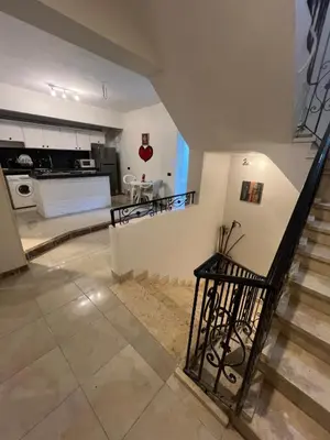 a kitchen and a staircase in a house at Mohamed Home in Jazīrat al ‘Awwāmīyah
