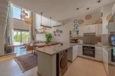 a kitchen with white cabinets and a counter top at Charming Jungle Home in Hurghada