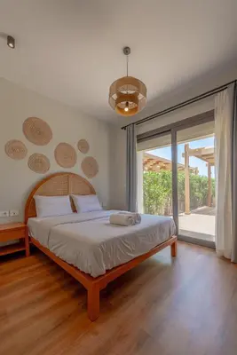 a bedroom with a bed and a large window at Charming Jungle Home in Hurghada