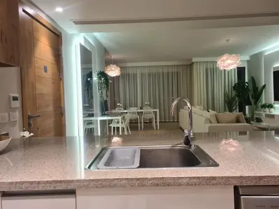 a kitchen with a sink and a living room at El Gouna - 3 Bedroom - Rooftop-Pool - Ancient Hills in Hurghada