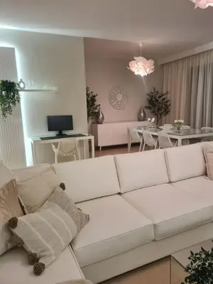 a living room with a white couch and a dining room at El Gouna - 3 Bedroom - Rooftop-Pool - Ancient Hills in Hurghada