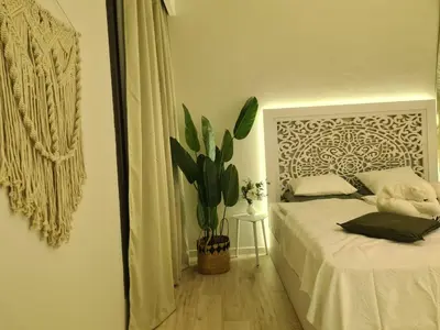 a bedroom with a white bed and a plant at El Gouna - 3 Bedroom - Rooftop-Pool - Ancient Hills in Hurghada