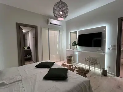 a bedroom with a large bed with a television on the wall at El Gouna - 3 Bedroom - Rooftop-Pool - Ancient Hills in Hurghada