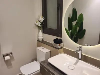 a bathroom with a toilet and a sink and a mirror at El Gouna - 3 Bedroom - Rooftop-Pool - Ancient Hills in Hurghada
