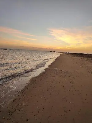 an empty beach at sunset with the ocean at Apartment in port Ghalib in Port Ghalib