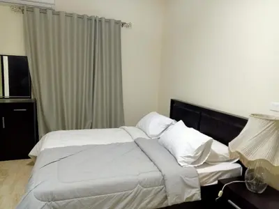 a bedroom with a bed with white sheets and pillows at Sun and fun Hurgadah Apartments in Hurghada