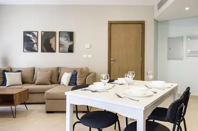 a living room with a white table and chairs at Glow & Tide 1BDR w Rooftop Mangroovy Free Pool & Beach Access in Hurghada