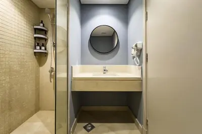 a bathroom with a sink and a mirror at Glow & Tide 1BDR w Rooftop Mangroovy Free Pool & Beach Access in Hurghada