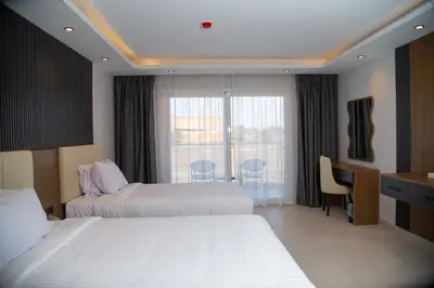 a hotel room with two beds and a window at Rewaya Majestic Resort in Hurghada
