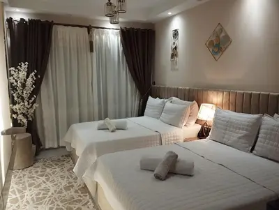 two beds in a hotel room with white sheets at Florenza khamsin Resort Hurghada Red Sea in Hurghada