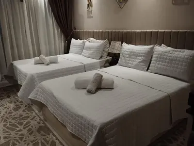 two beds in a bedroom with white sheets and pillows at Florenza khamsin Resort Hurghada Red Sea in Hurghada