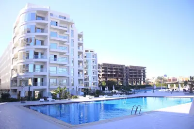 a large apartment building next to a swimming pool at Modern loft overlooking downtown in Scandic Resort in Hurghada