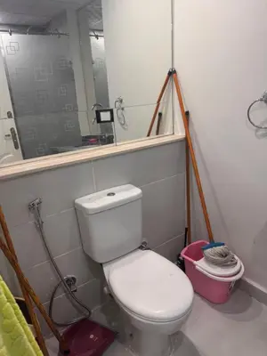 a bathroom with a white toilet and a mirror at Modern loft overlooking downtown in Scandic Resort in Hurghada