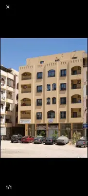 a large building with cars parked in front of it at Bayt Hassan A7 - fabulous 2 bedrooms apartment in Hurghada
