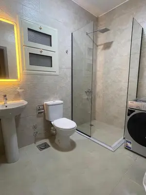 a bathroom with a shower and a toilet and a sink at Bayt Hassan A7 - fabulous 2 bedrooms apartment in Hurghada