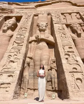 a woman is standing in front of anaraoh at abu simbel and luxor trip in Jazīrat Suhayl