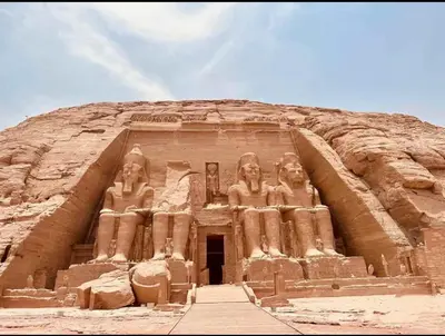 a building with statues on the front of it at abu simbel and luxor trip in Jazīrat Suhayl