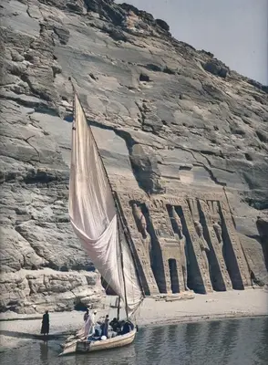a sail boat in the water in front of a building at abu simbel and luxor trip in Jazīrat Suhayl