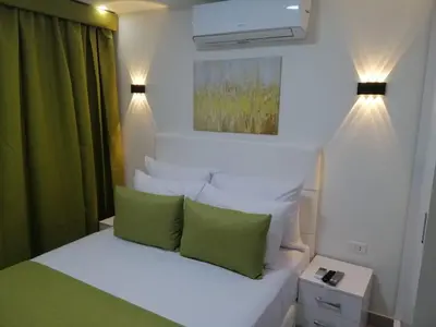 a bedroom with a bed with green and white pillows at Selena Bay Resort in Hurghada