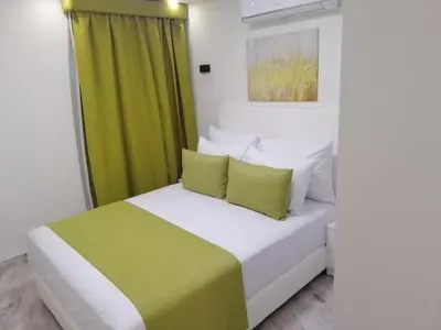 a bed with green and white pillows in a room at Selena Bay Resort in Hurghada