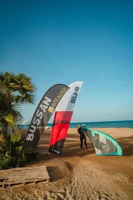 two people are on the beach with kites at Selena Bay Resort in Hurghada