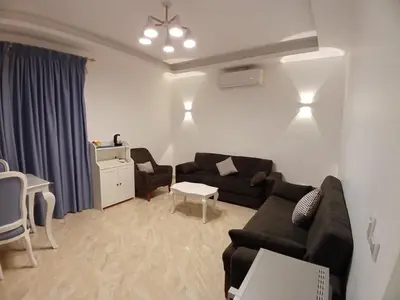 a living room with a black couch and a table at Selena Bay Resort in Hurghada