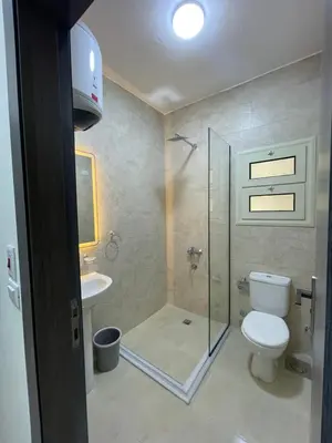 a bathroom with a shower and a toilet and a sink at Bayt Hassan S10 - Fabulous one bedroom apartment in Hurghada