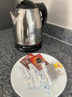 a plate with a tea kettle and a packet of sugar at Bayt Hassan S6 - Cosy 1 bedroom apartment in Hurghada