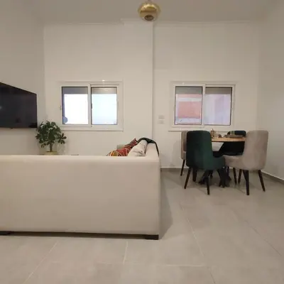 a living room with a white couch and a table at Arabic Apartment in Hurghada