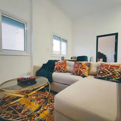 a living room with a couch and a glass table at Arabic Apartment in Hurghada