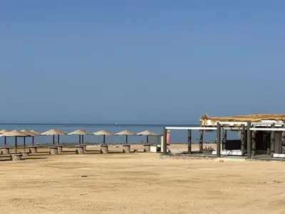 a row of umbrellas on a beach with the ocean at فنادير باي in Hurghada