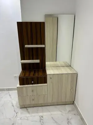 a wooden dresser with a mirror on a wall at فنادير باي in Hurghada