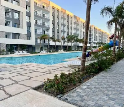 a swimming pool in front of a large apartment building at فنادير باي in Hurghada
