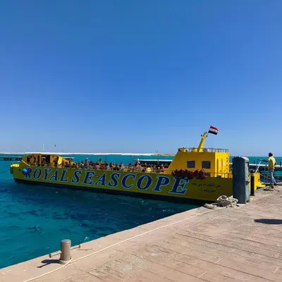 a yellow boat in the water next to a dock at Boho Apartment in Hurghada
