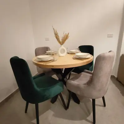 a dining room table with chairs and a vase on it at Boho Apartment in Hurghada