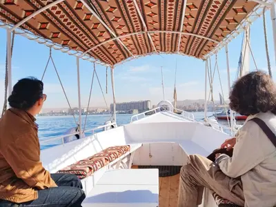 two people sitting on a boat in the water at Garden view in Aswan