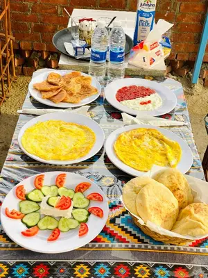 a table with plates of food on it at Garden view in Aswan