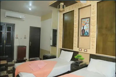 a bedroom with two beds with a pink towel on them at El Massa in Idfu