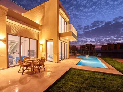 a house with a table and chairs and a swimming pool at El Gouna Villa in Tawila with private pool in Hurghada