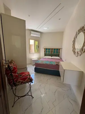 a bedroom with a bed and a chair and a mirror at Arabia Sea View in Hurghada